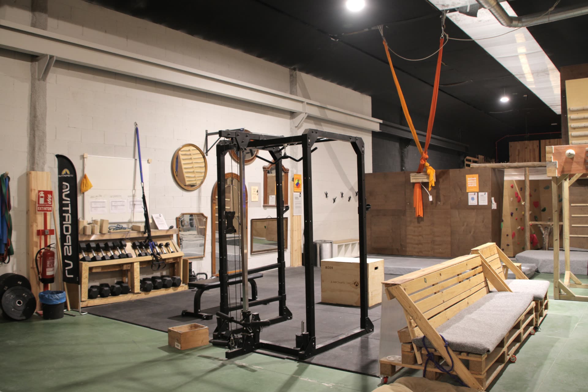 Gimnasio de Neko Escalada con jaula, mancuernas, multipresas y zona de entrenamiento
